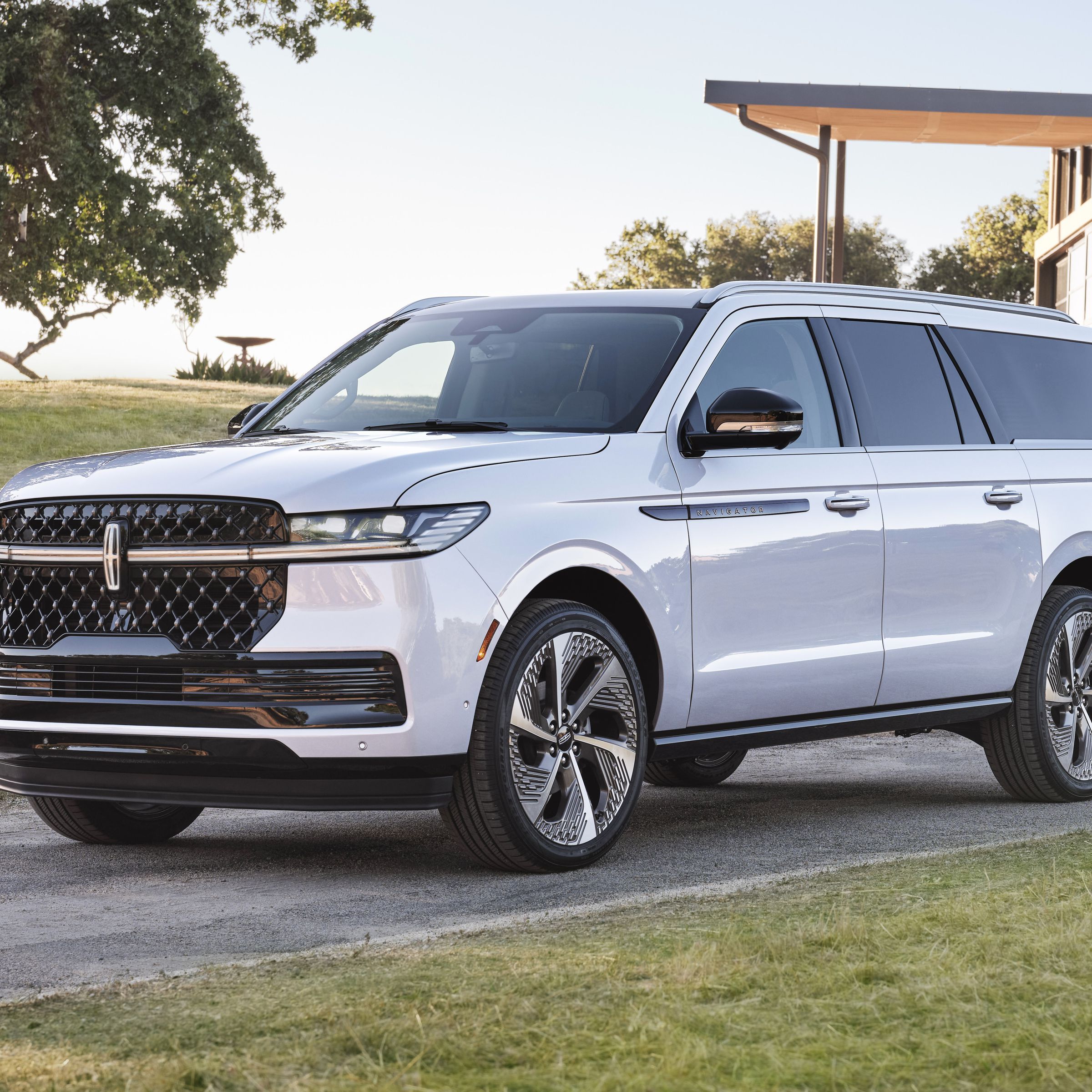 Big white SUV in front of a modern building