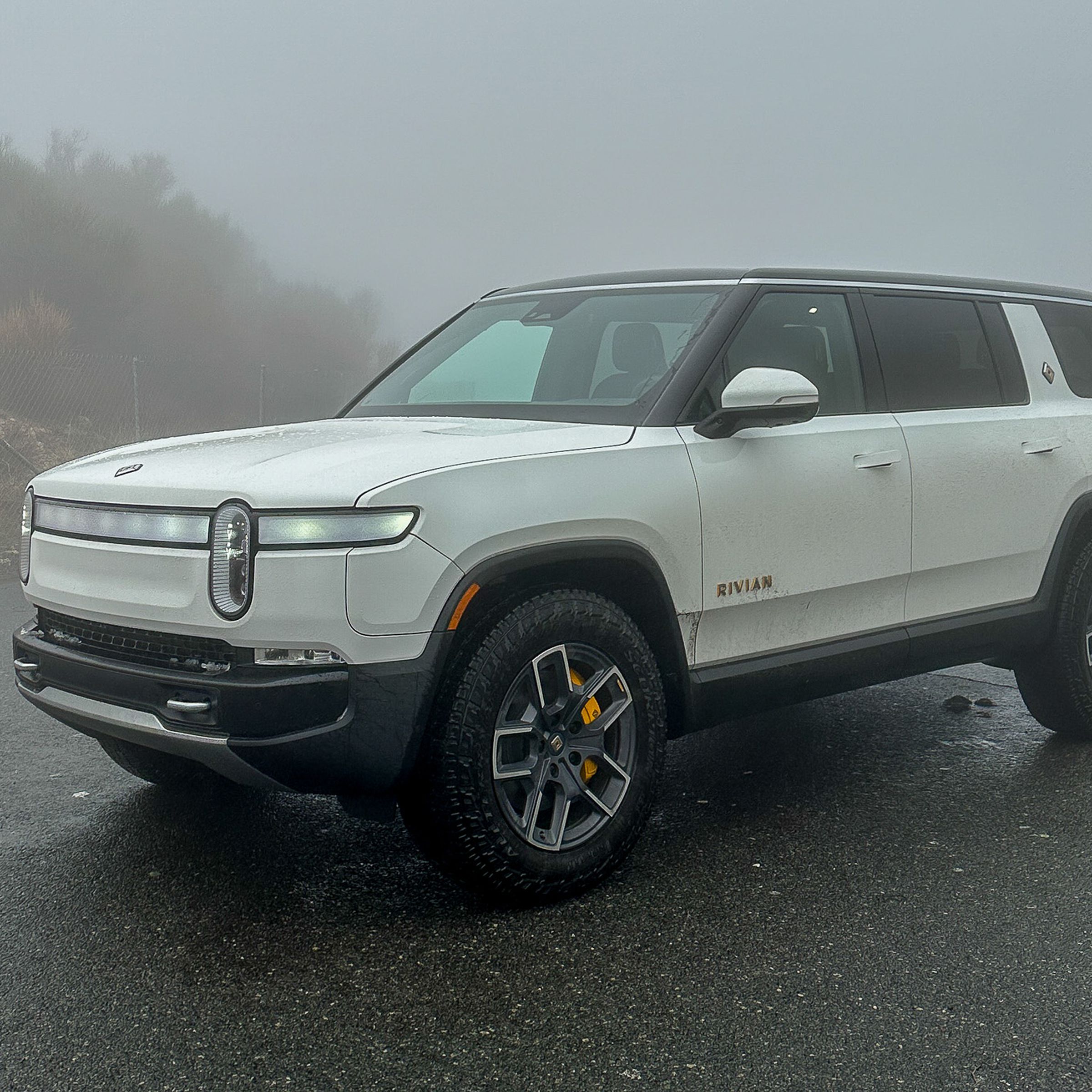 White R1S SUV in a foggy environment