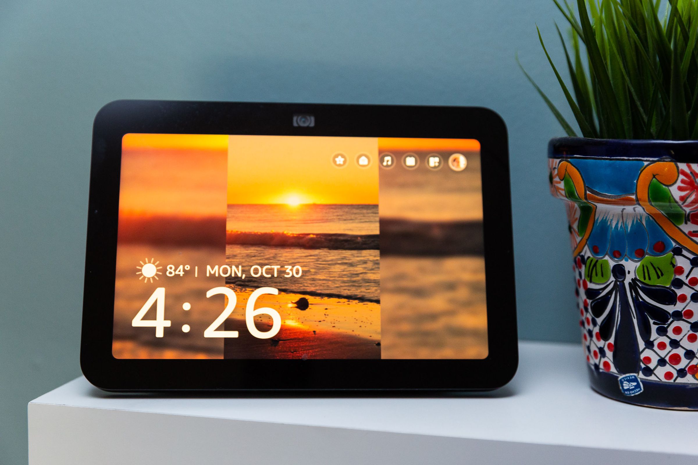 The third-generation Echo Show facing the camera with its display on and four widgets up in the top right corner.