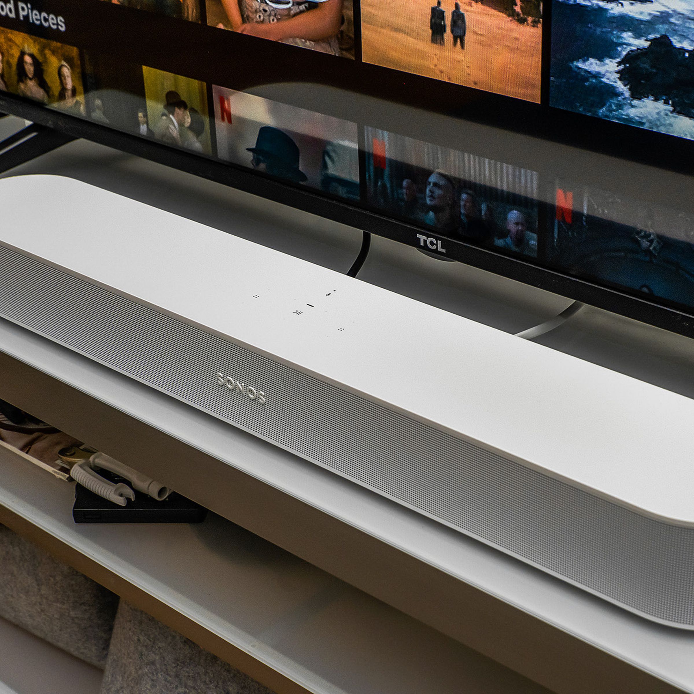 A photo of the white second-generation Sonos Beam soundbar in front of a TV