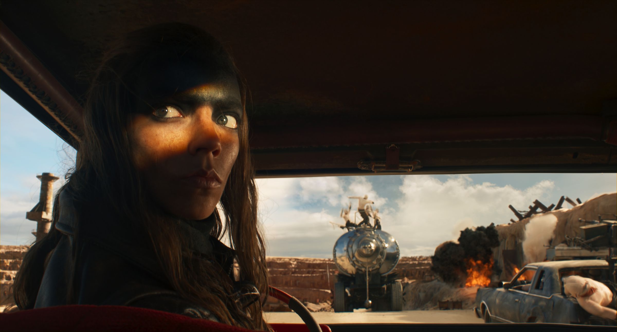 A woman looking over her shoulder out the rear window of a car.