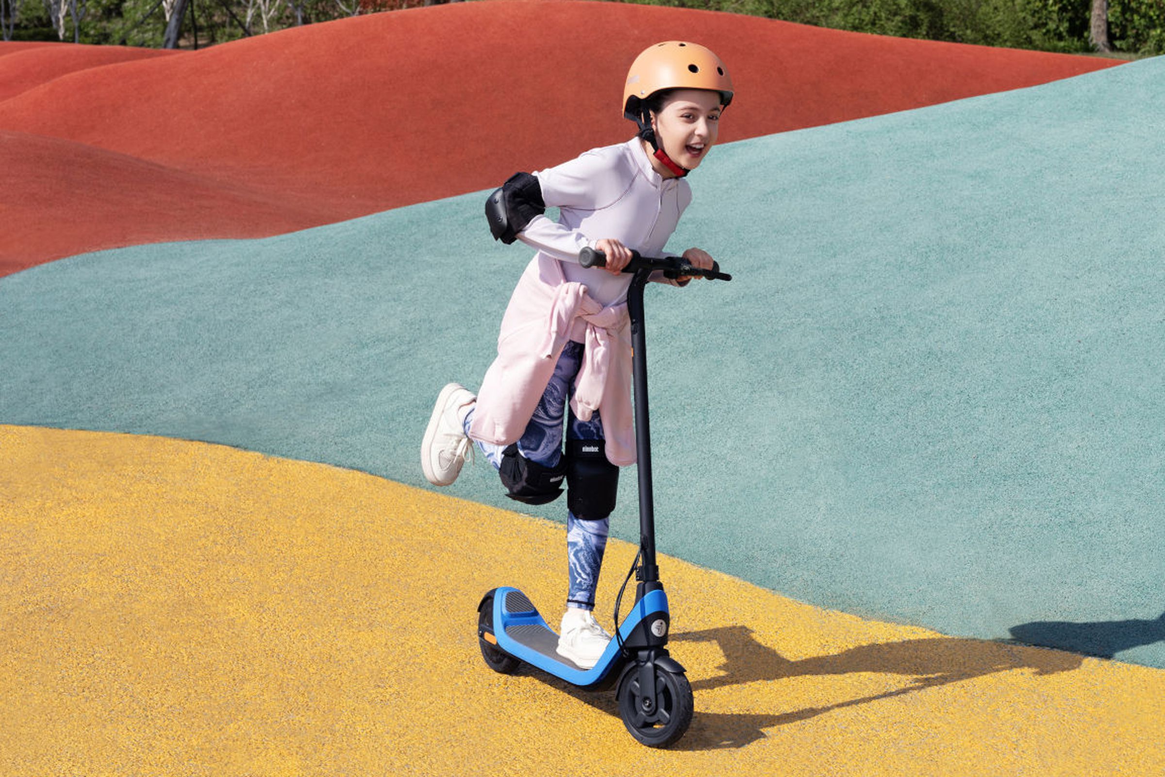 A child riding the Segway Ninebot eKickScooter C2 Lite using its power assist kick mode.